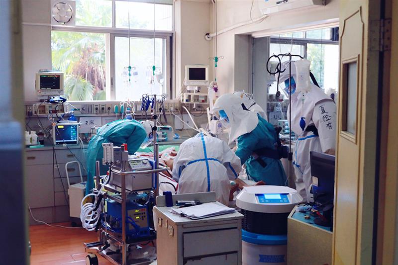 中部战区总医院感染专区重症监护室医护人员对重症患者做俯卧位通气治疗前的准备工作（3月5日摄）。  新华社发（王震 摄)