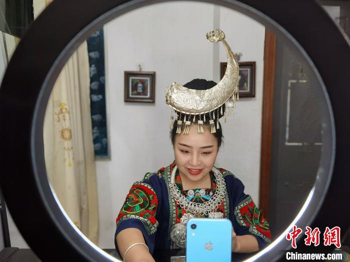 换上苗族服饰的潘雪在直播带货。　周燕玲 摄