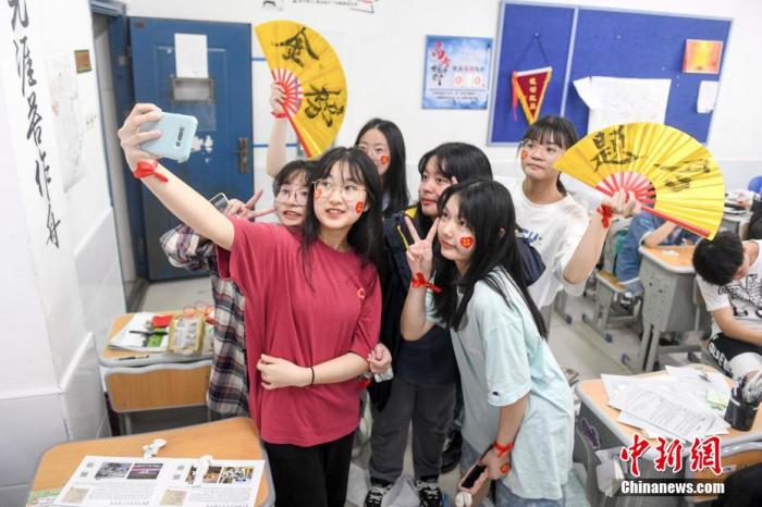 资料图:6月6日,2021年高考前夕,湖南长沙同升湖实验学校高三年级,考生们在教室内合影。 杨华峰 摄 点击进入下一页