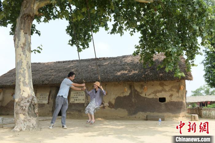 7月1日,民众在“中国农村改革第一村”——安徽省凤阳县小岗村“茅草屋”景点荡秋千。 张娅子 摄 7月1日,民众在“中国农村改革第一村”——安徽省凤阳县小岗村“茅草屋”景点荡秋千。 张娅子 摄
