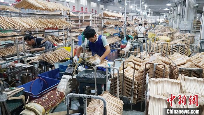 广西荔浦被誉为“中国衣架之都”，2020年衣架家居产业产值近20亿元人民币，其中80���出口欧美、东南亚等国家和地区。资料图为工人在组装衣架。 <a target='_blank' href='http://www.chinanews.com/'>中新社</a>发 欧惠兰 摄
