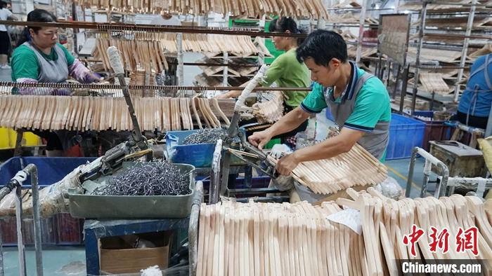 广西荔浦被誉为“中国衣架之都”，2020年衣架家居产业产值近20亿元人民币，其中80���出口欧美、东南亚等国家和地区。资料图为工人在组装衣架。 <a target='_blank' href='http://www.chinanews.com/'>中新社</a>发 欧惠兰 摄