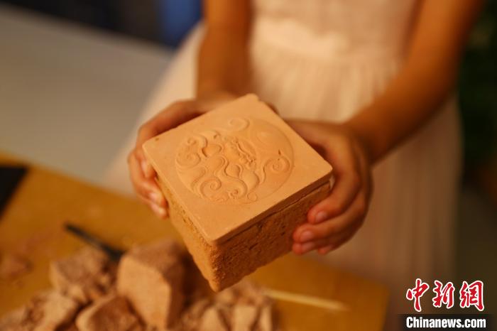 图为江西省博物馆天工坊，一名游客准备打开“考古盲盒”文创产品。　刘占昆 摄